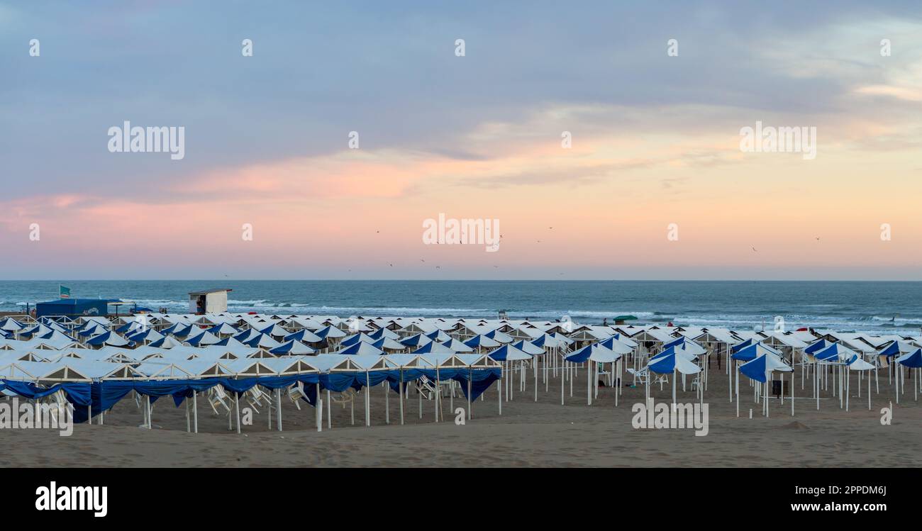 Necochea, Buenos Aires, Argentina. January 19, 2021. View of the ocean with many gazebo and umbrellas for vacationers, blue hour Stock Photo