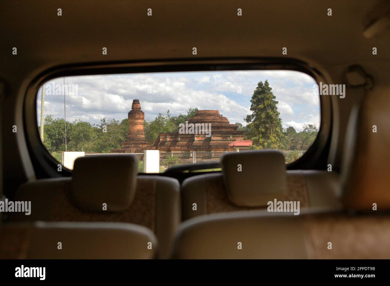 Muara Takus temple compound is photographed from inside a car in Muara