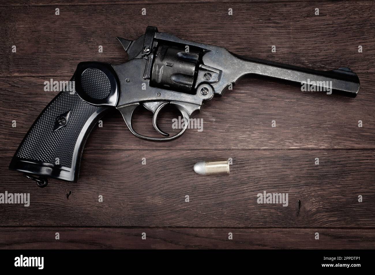 British Army Revolver with ammunition on wooden table Stock Photo