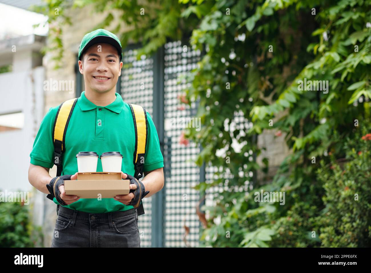 Smiling young man in uniform working as courier Stock Photo