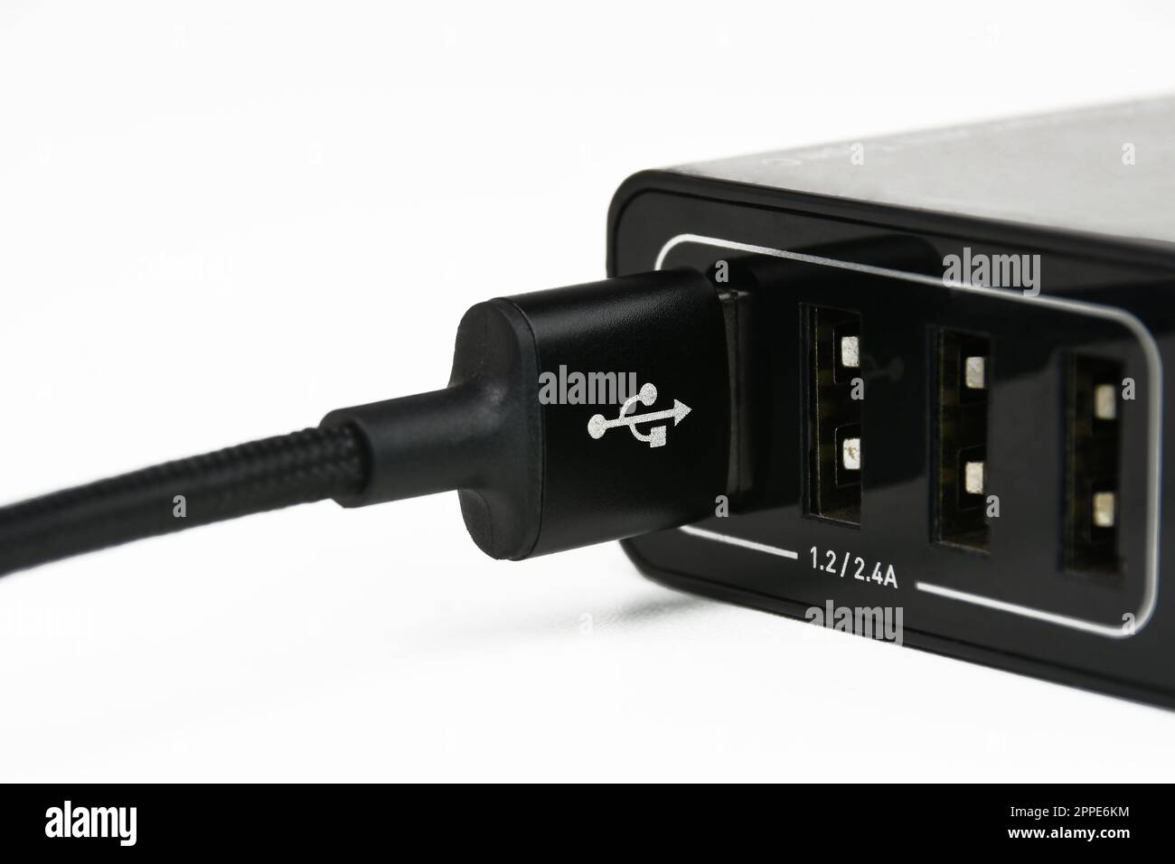 USB A charging cable in mobile phone charger port on white background