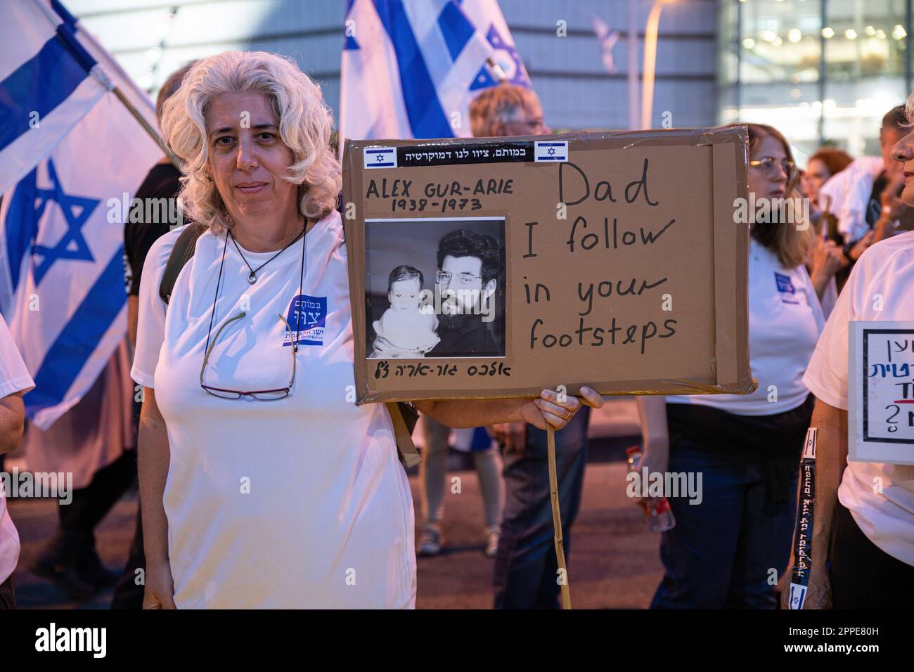 Tel Aviv, Israel. 22nd Apr, 2023. Yaara (49) daughter of Alex Gur-Arie, who died as a soldier at the 73í Yom Kippur war, holds a poster of her and her father's photo during an anti judicial overhaul demonstration in Tel Aviv. Credit: SOPA Images Limited/Alamy Live News Stock Photo