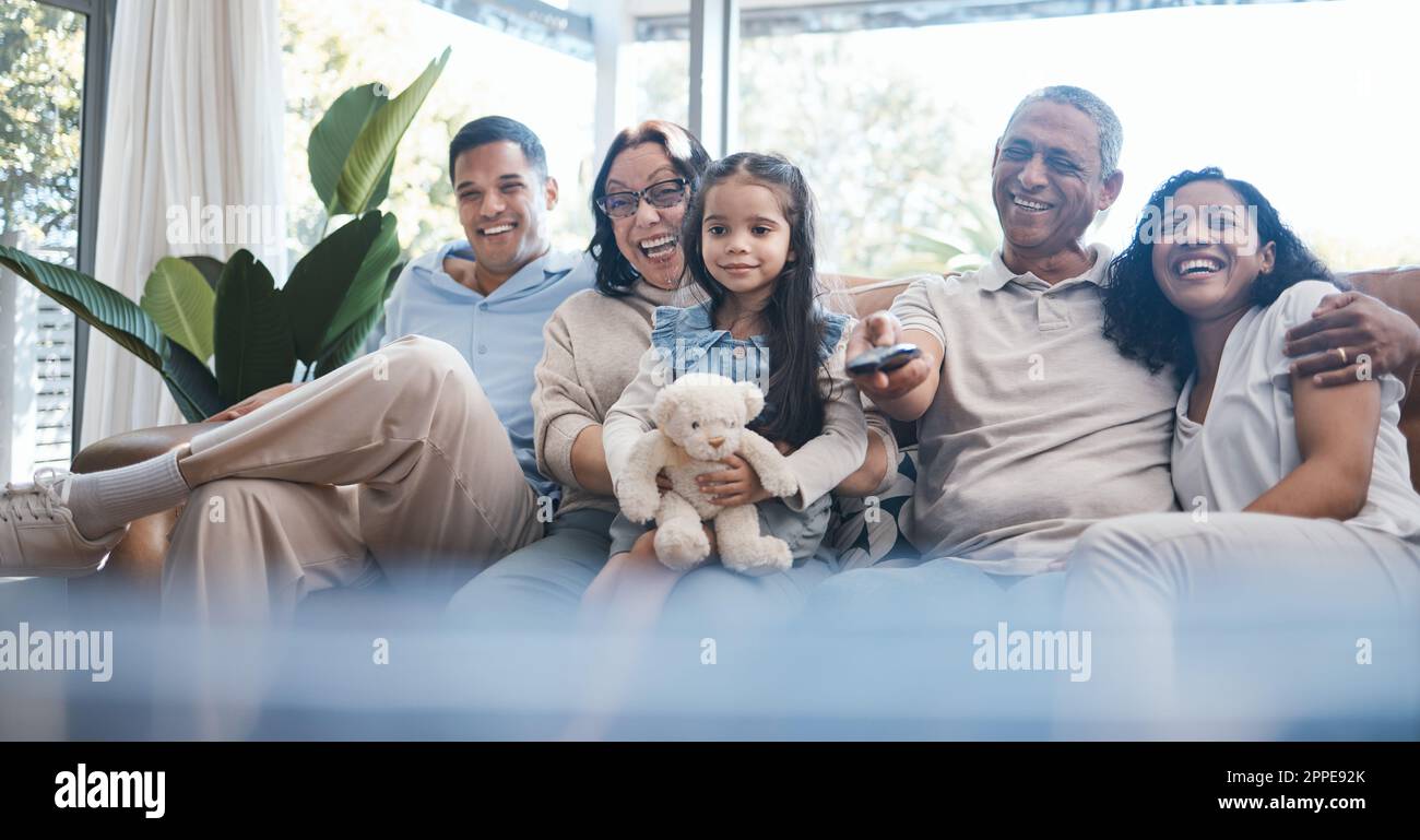 Happy family watching tv with parents, grandparents and child on sofa in living room, happiness and quality time together. Kid with teddy bear, women Stock Photo