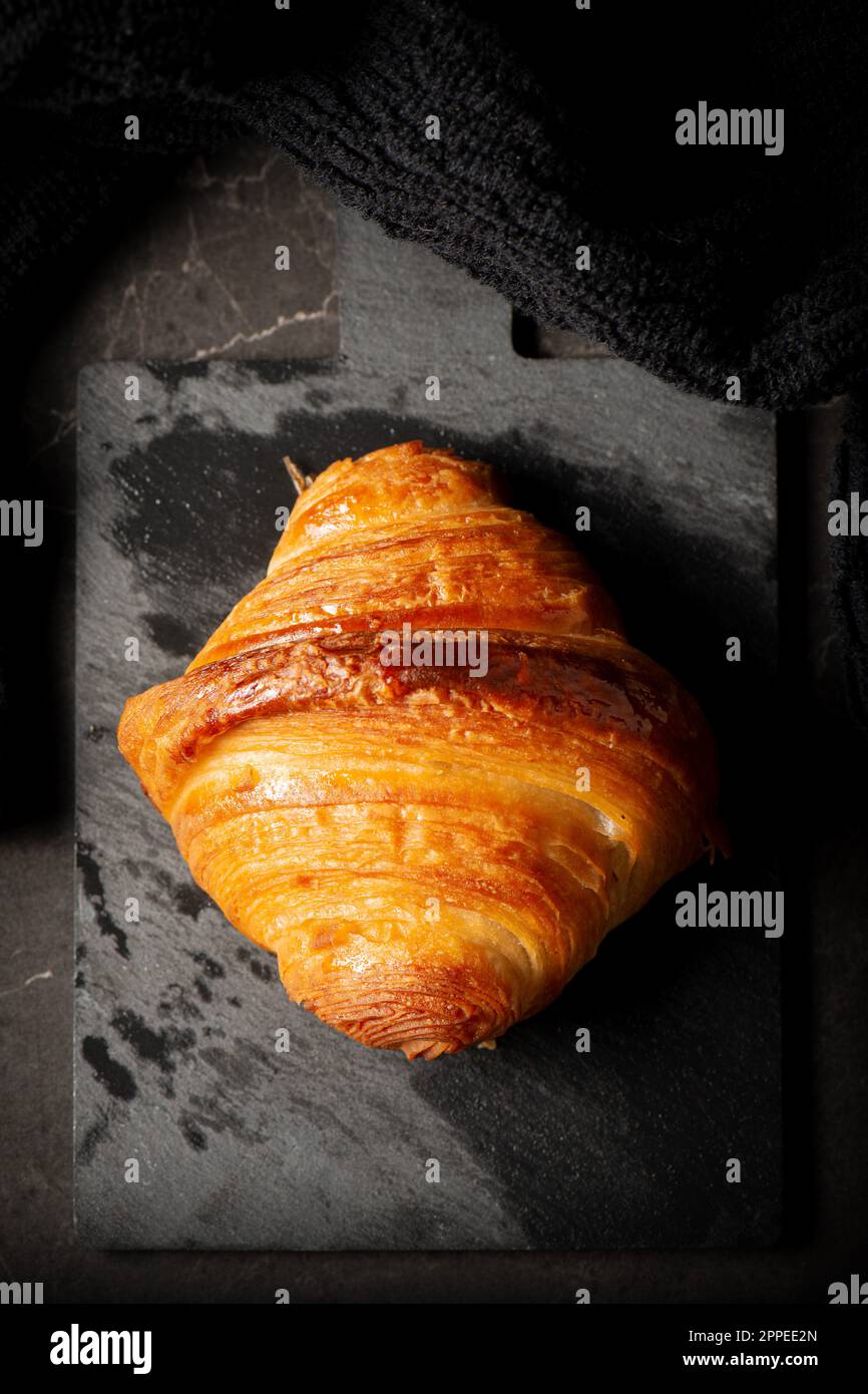 Delicious golden brown baked crispy and flaky plain buttery croissant. Stock Photo