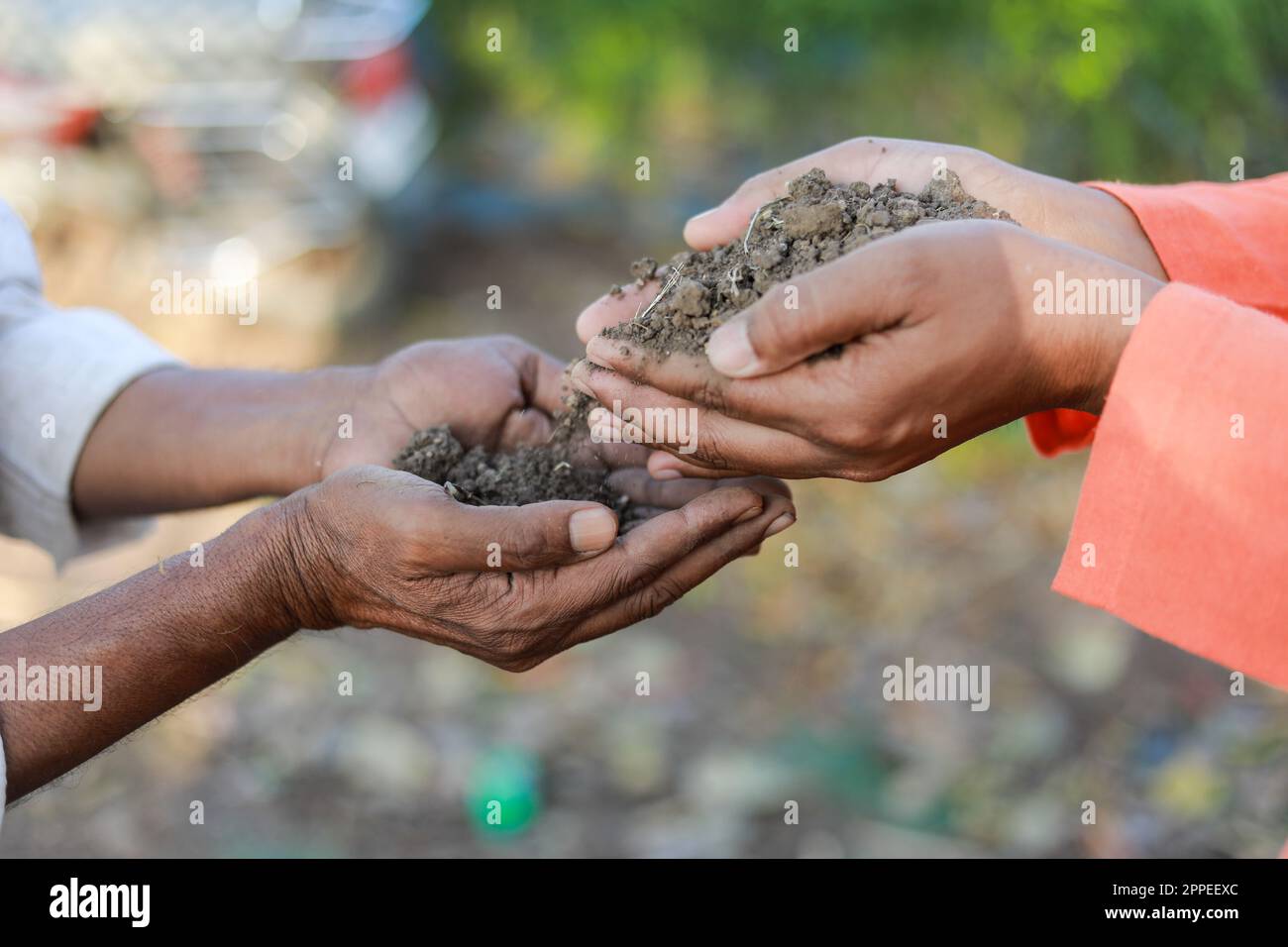 Indian farmer holding soil in hands, happy farming, Dropping soil in other hand Stock Photo
