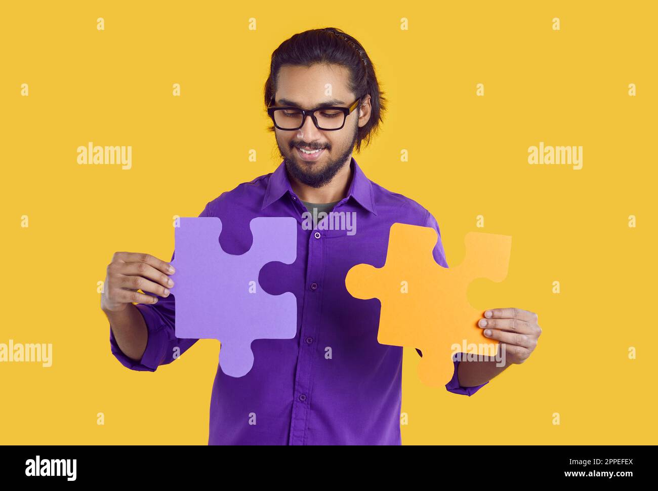 Indian guy connect jigsaw puzzle pieces Stock Photo Alamy