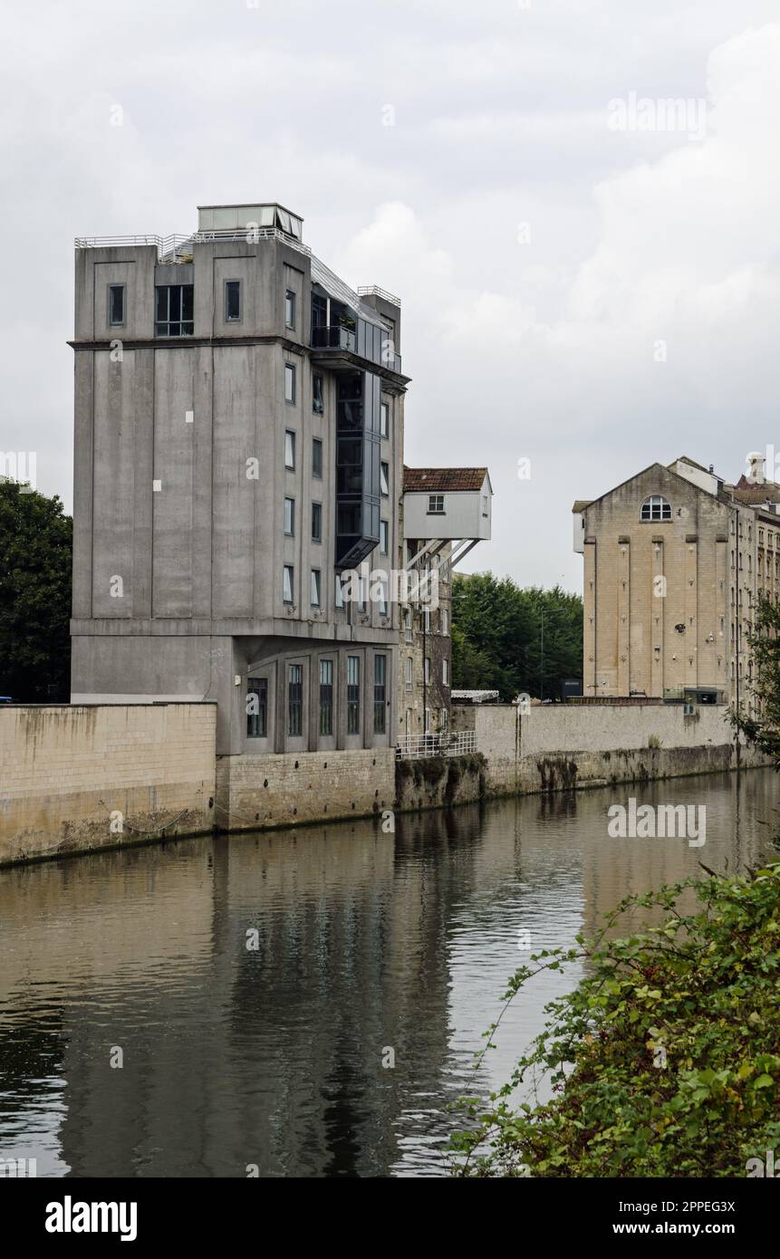 Historic warehouses, now converted into apartments and offices on the wharf beside the River Avon in Bath, Somerset viewed on a cloudy September day. Stock Photo