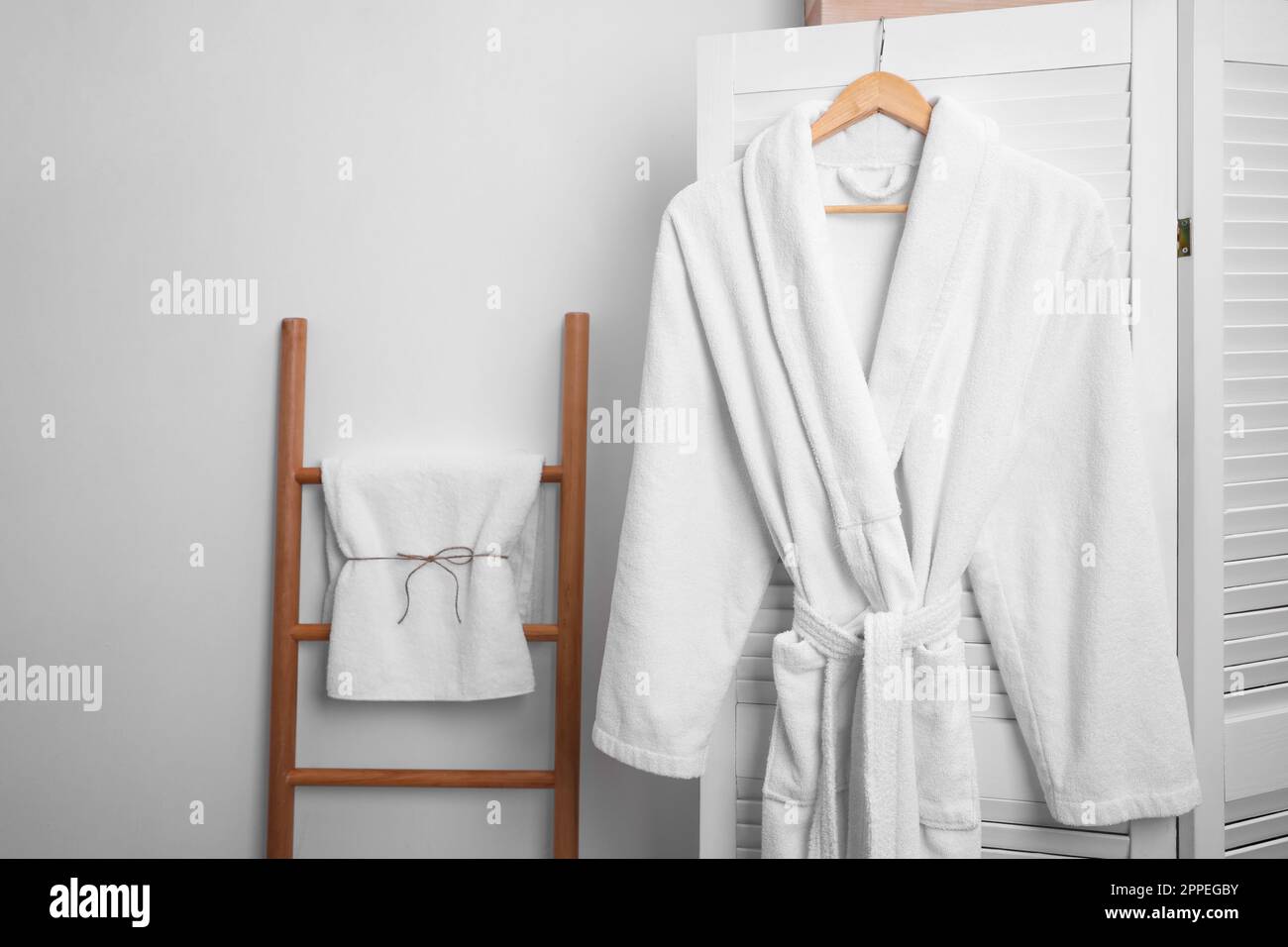 Hanger with clean soft bathrobe on screen Stock Photo Alamy