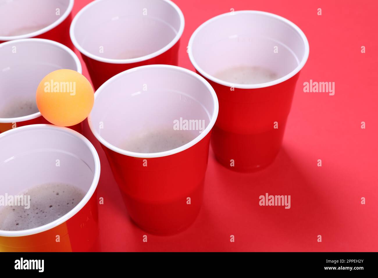 https://c8.alamy.com/comp/2PPEH2Y/plastic-cups-and-ball-for-beer-pong-on-red-background-2PPEH2Y.jpg