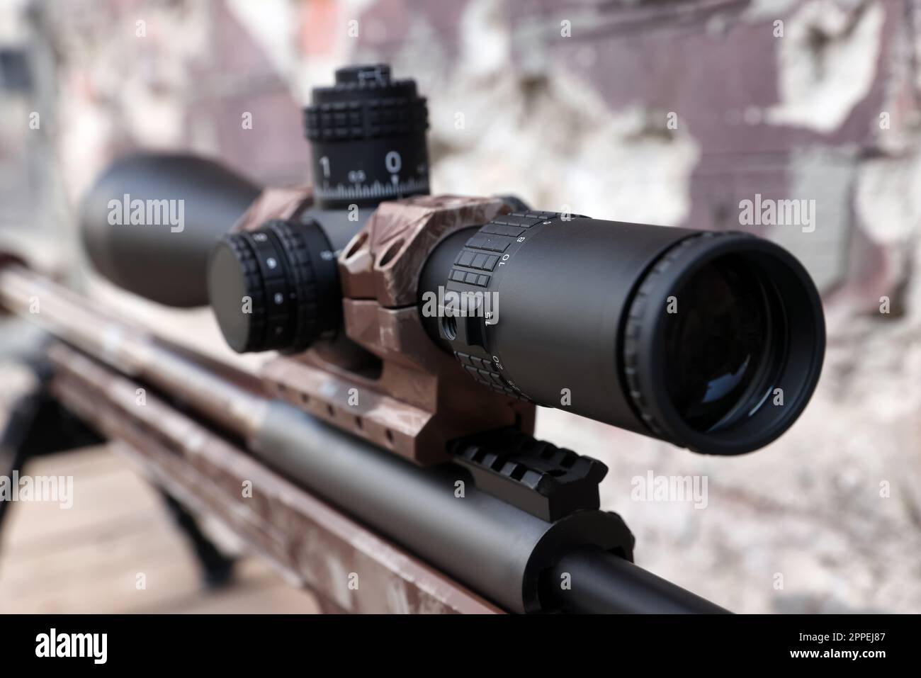 Closeup view of modern powerful sniper rifle with telescopic sight on blurred background Stock