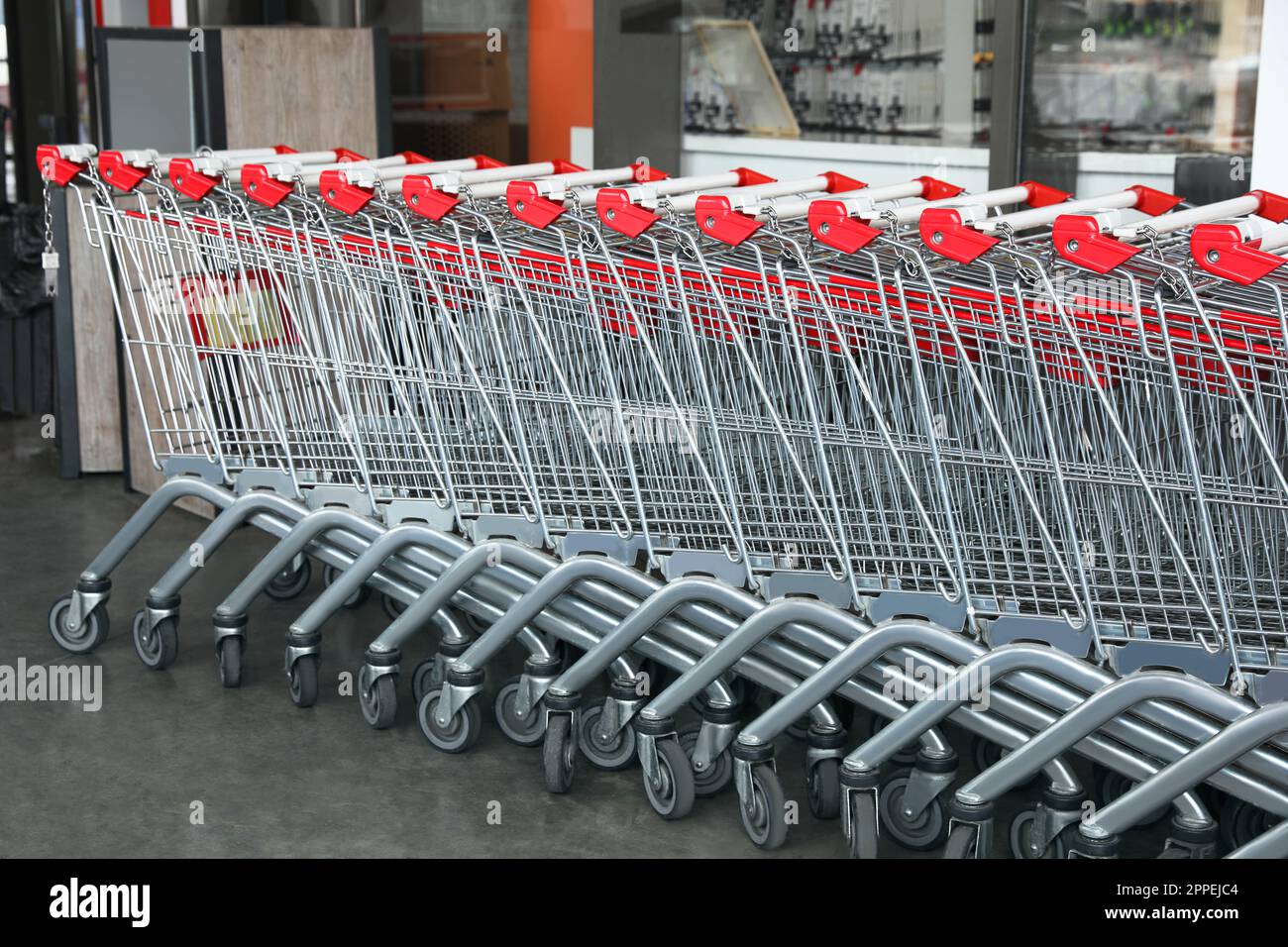 Row of empty metal shopping carts near supermarket outdoors Stock Photo