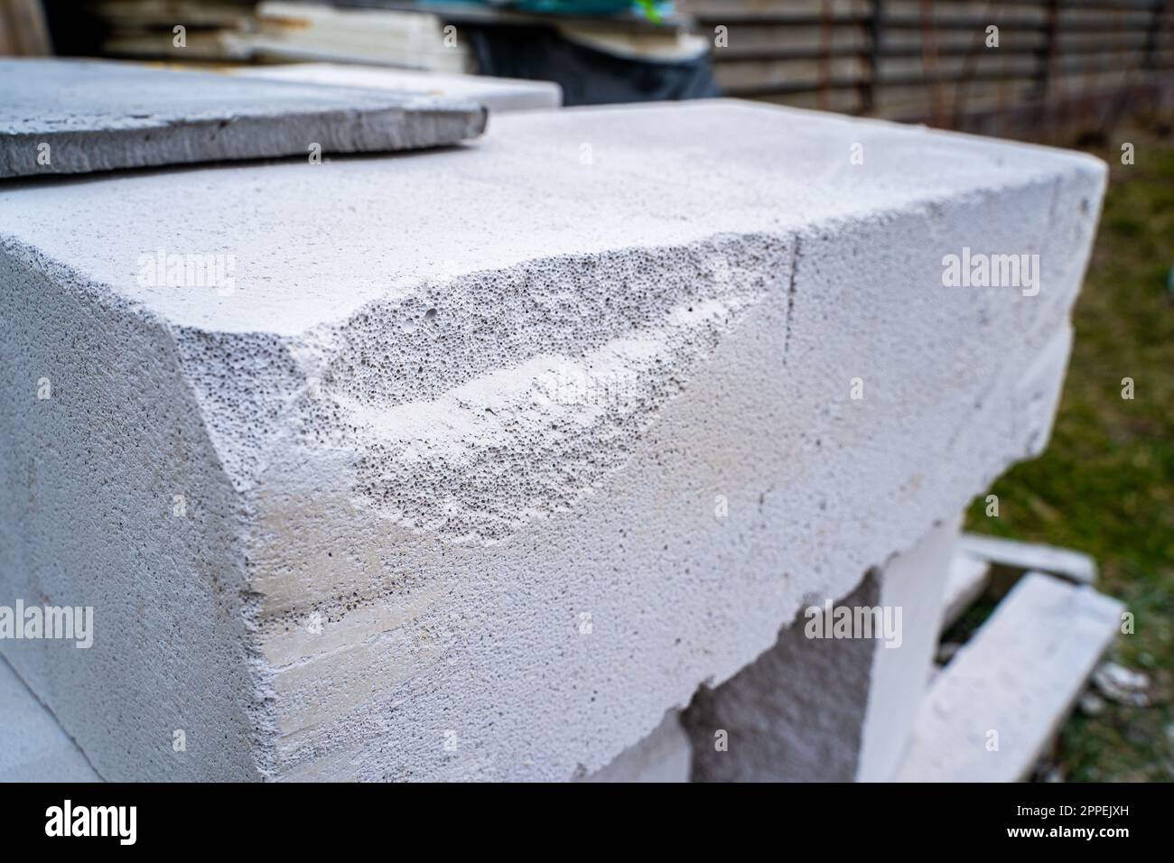 Broken corner of aerated concrete brick closeup. Impacted aerated