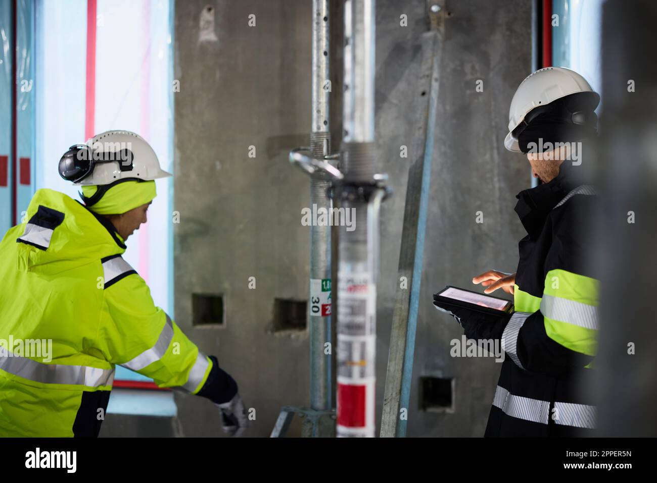 Male and female engineer working at construction site Stock Photo