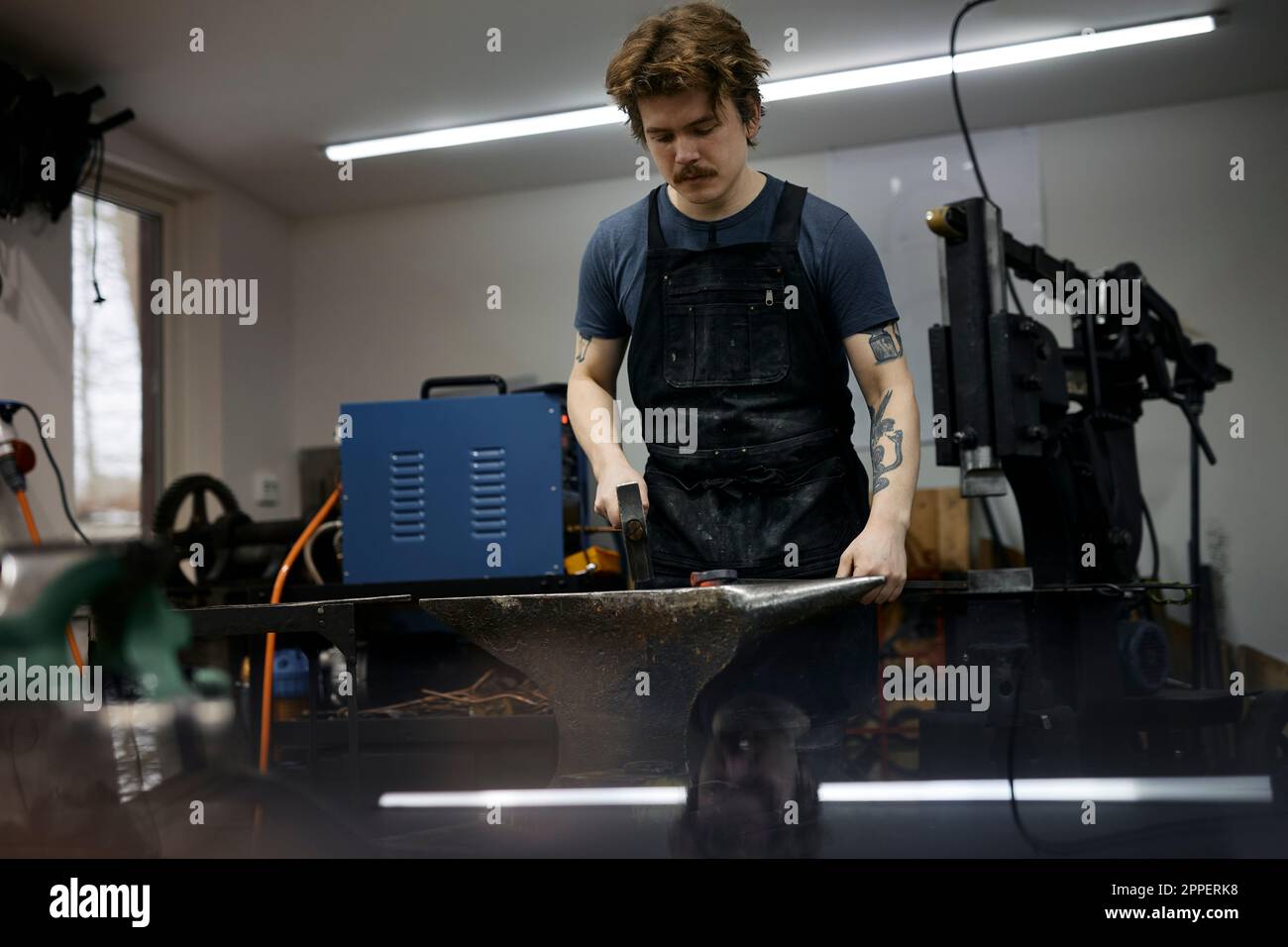 Blacksmith working in his workshop Stock Photo