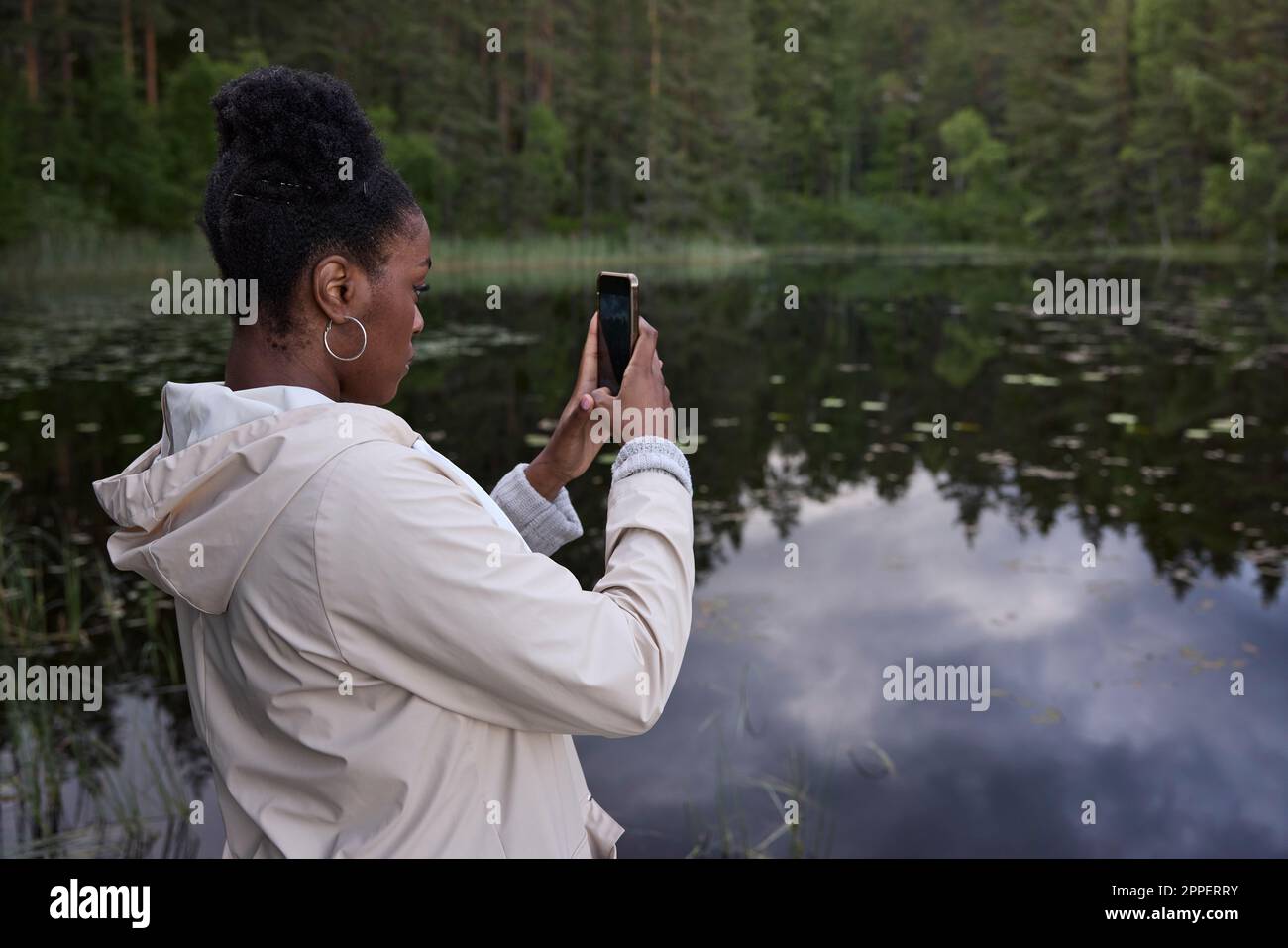 Young woman taking photo with cell phone Stock Photo