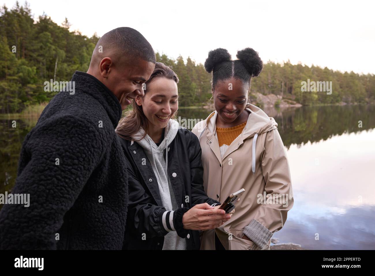 Young friends looking at cell phone Stock Photo