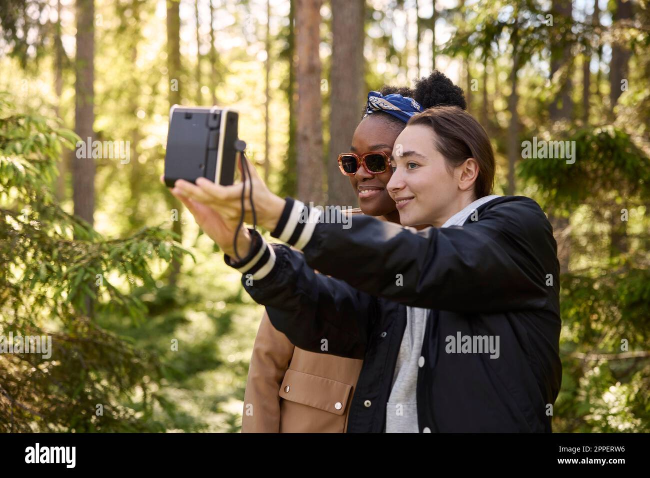 Smiling women taking selfie in forest Stock Photo
