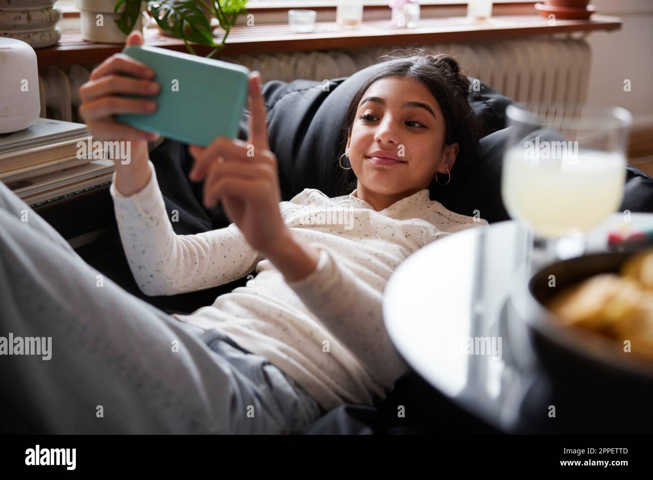 Girl lying on bean bag and taking selfie Stock Photo - Alamy