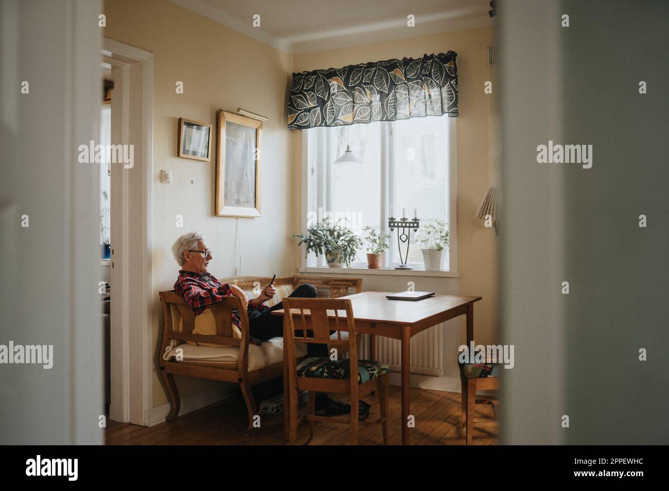 Senior man using smart phone at home Stock Photo