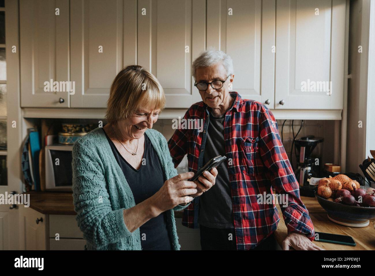 Senior couple using smart phone at home Stock Photo