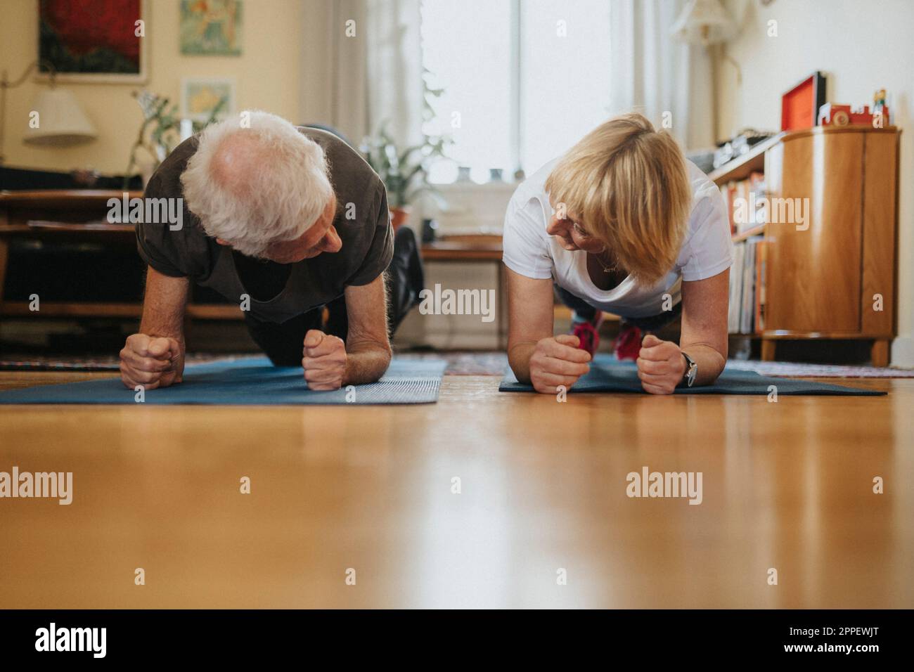 Senior couple doing planks at home Stock Photo