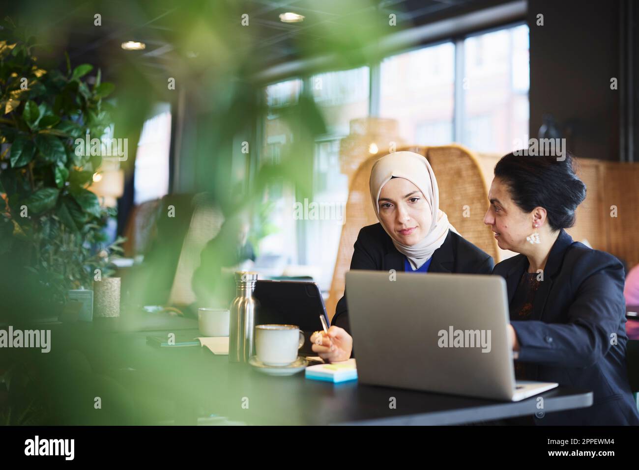 Businesswomen using digital tablet in cafe Stock Photo