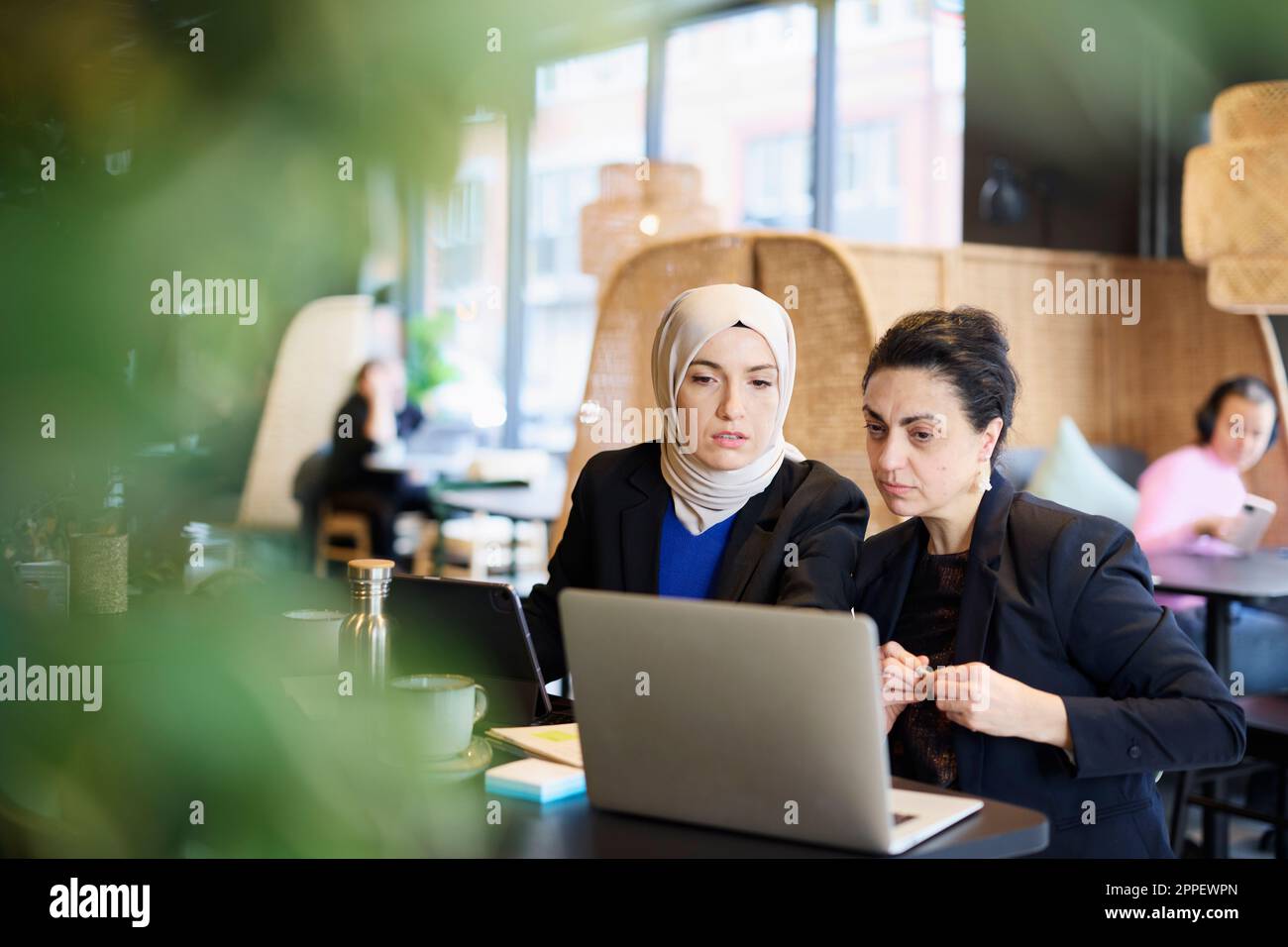 Businesswomen using digital tablet in cafe Stock Photo