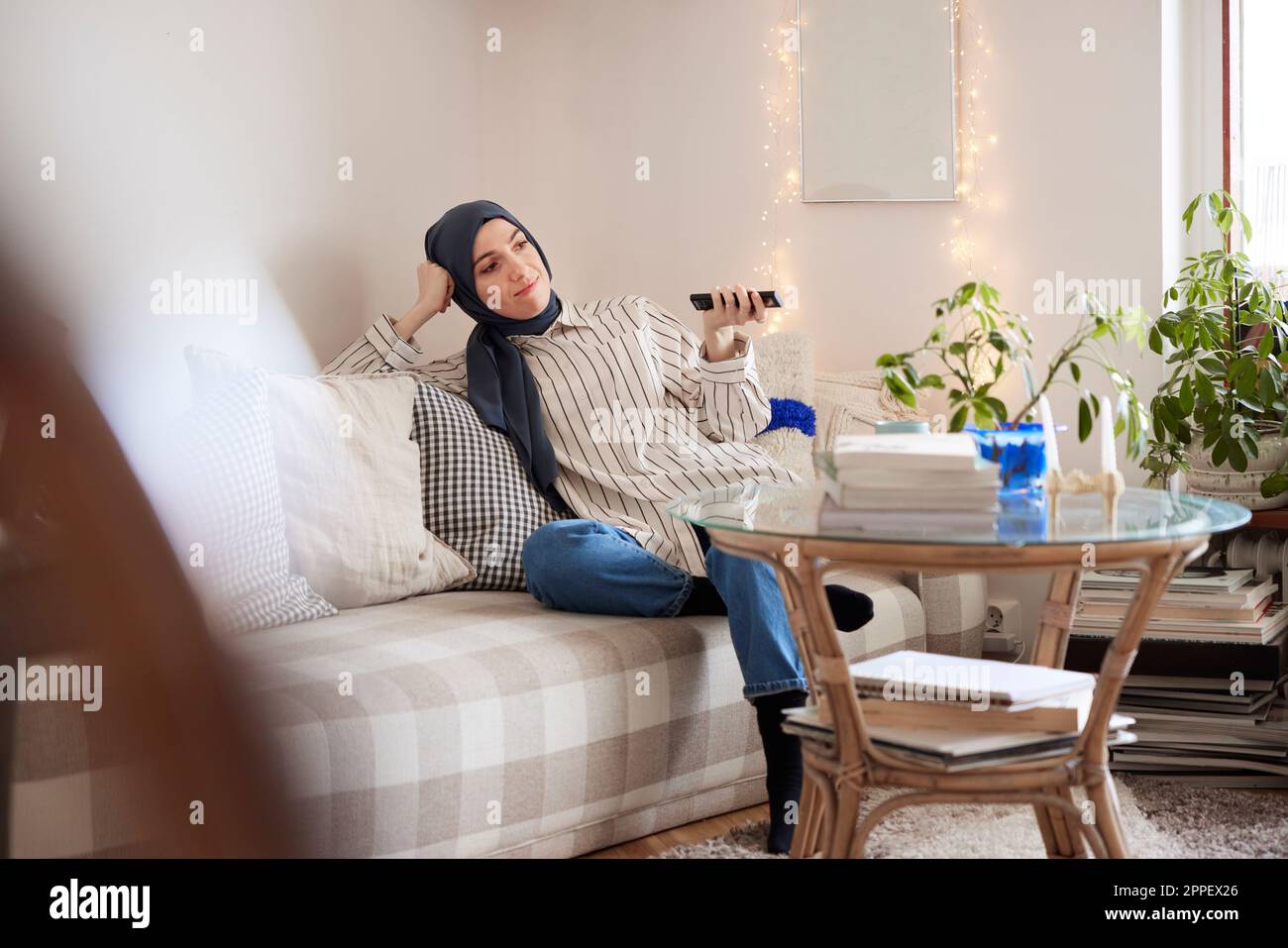 Woman sitting on sofa in living room hi-res stock photography and ...
