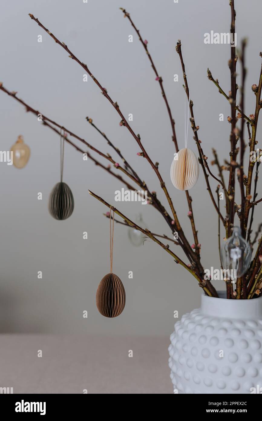 Twigs with paper Easter eggs hanging on them Stock Photo