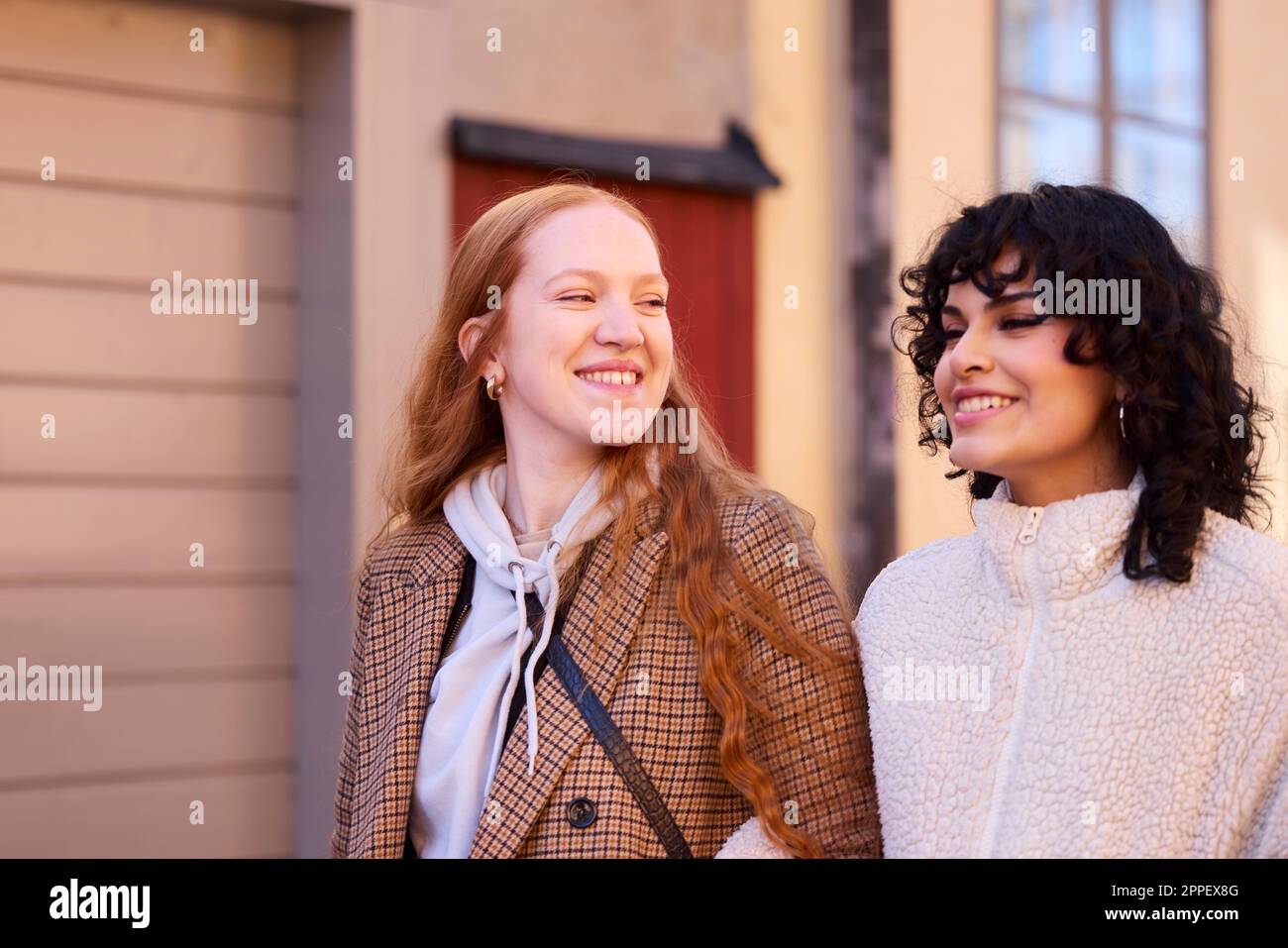 Smiling young women walking outdoors Stock Photo