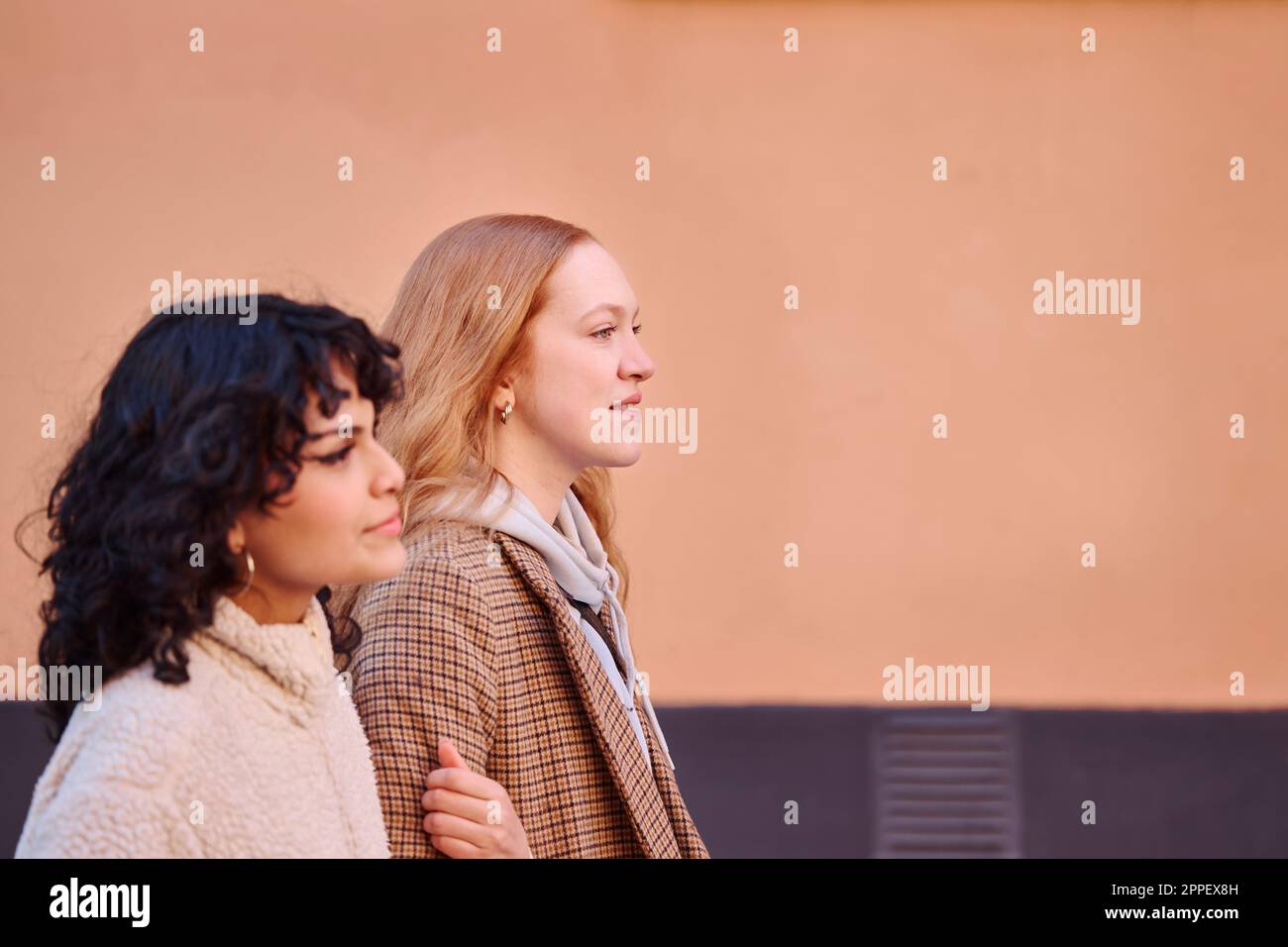 Smiling young women walking outdoors Stock Photo