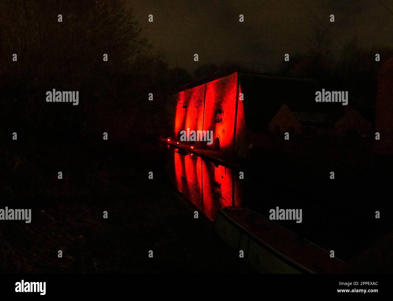 Red lights illuminating a brick wall and reflected back onto the canal at the Black Country Living Museum Dudley. March 2023 Stock Photo