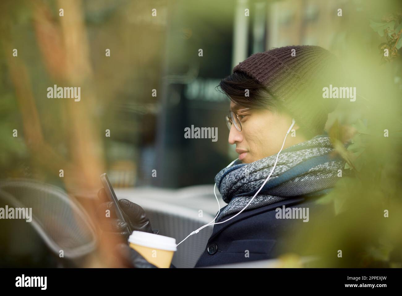 Man using cell phone in outdoor cafe Stock Photo