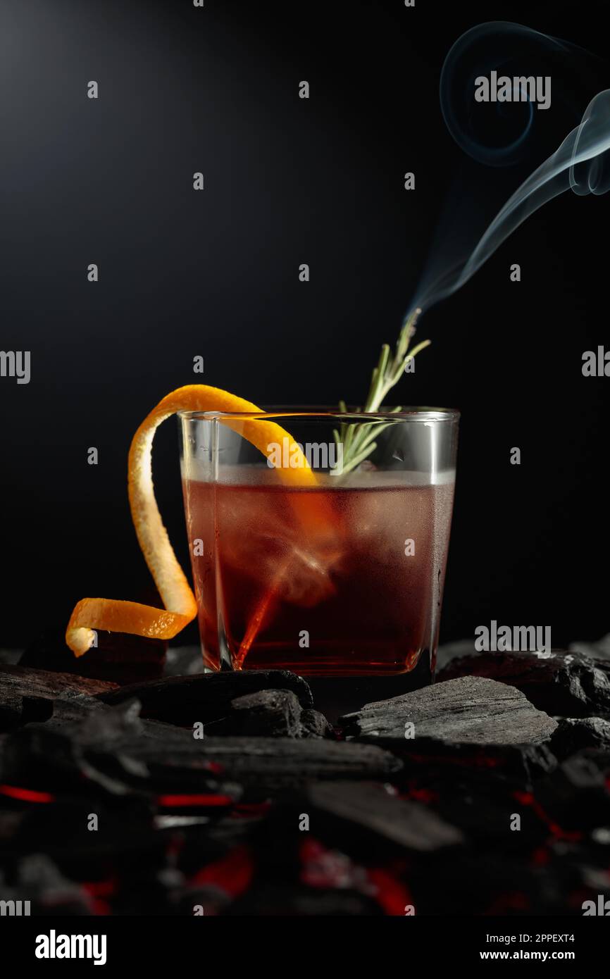 Oldfashioned cocktail with ice, orange peel, and rosemary. Whiskey