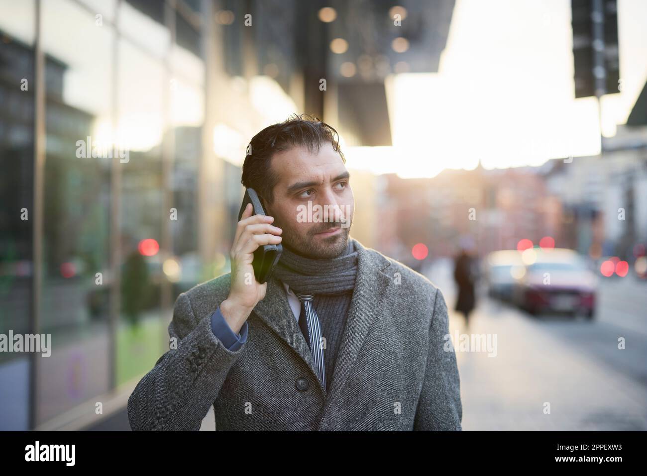 Businessman talking on phone outdoors Stock Photo