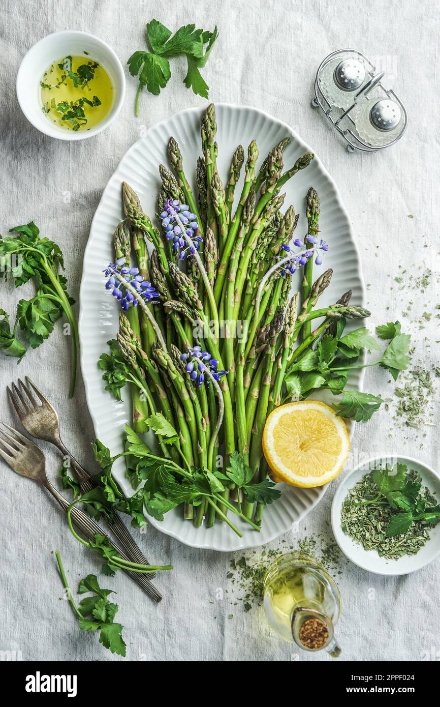 Green asparagus in plate with cooking ingredients, top view Stock Photo