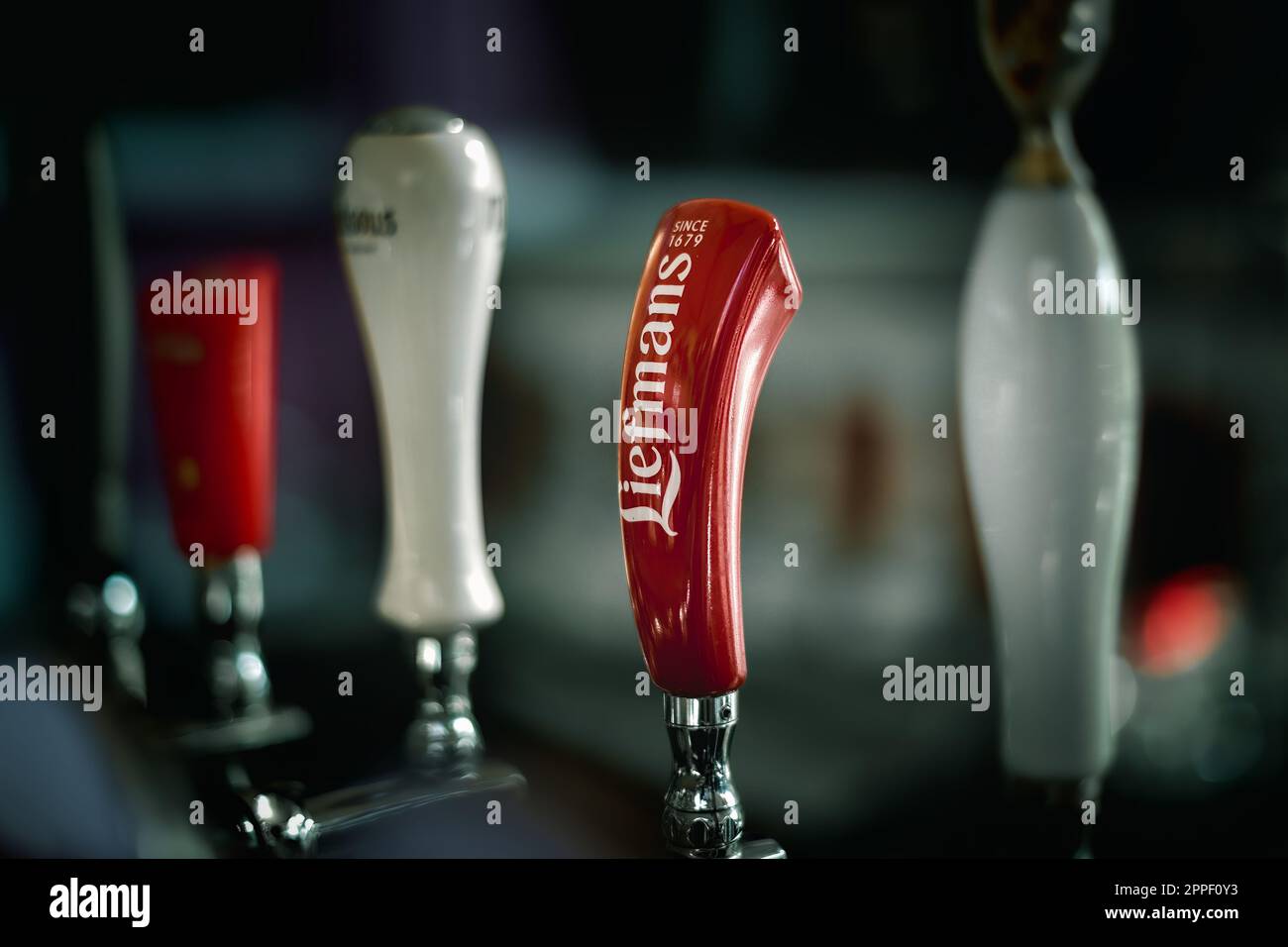 Handles of different brands of draft beer on a bar counter Stock Photo