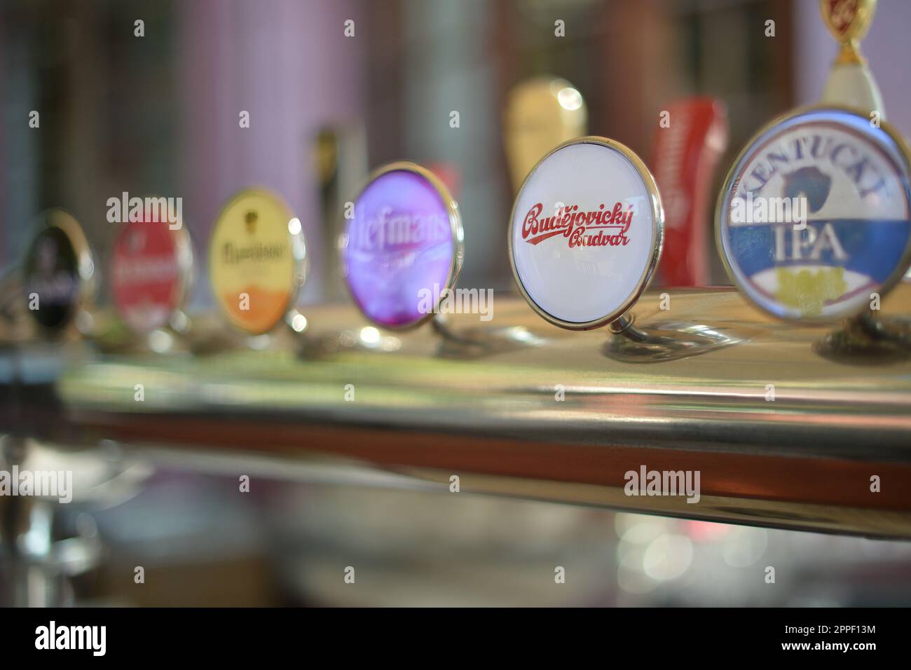 Handles of different brands of draft beer on a bar counter Stock Photo