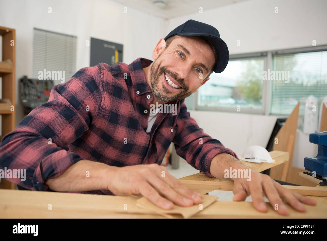 man sanding a wood with sander in a workshop Stock Photo - Alamy