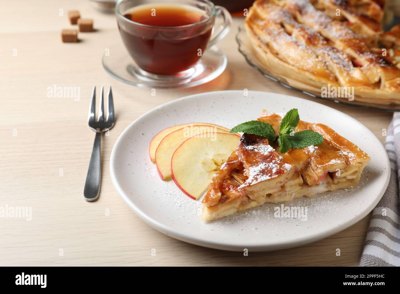 Slice of traditional apple pie served on wooden table Stock Photo