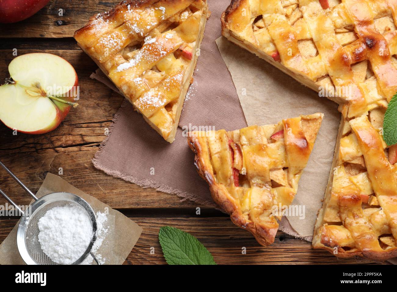 Traditional apple pie and ingredients on wooden table, flat lay Stock Photo