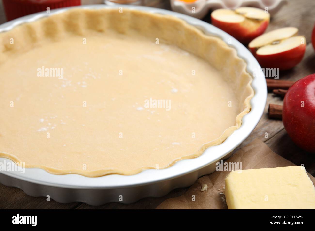 Raw dough for traditional English apple pie on wooden table, closeup Stock Photo