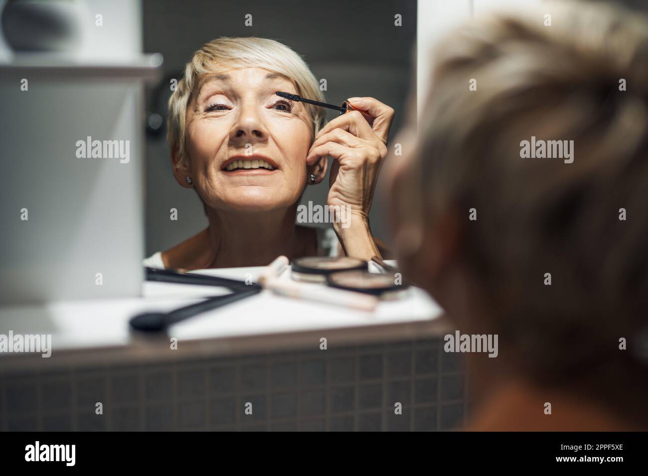 Senior woman applying mascara hi-res stock photography and images - Alamy