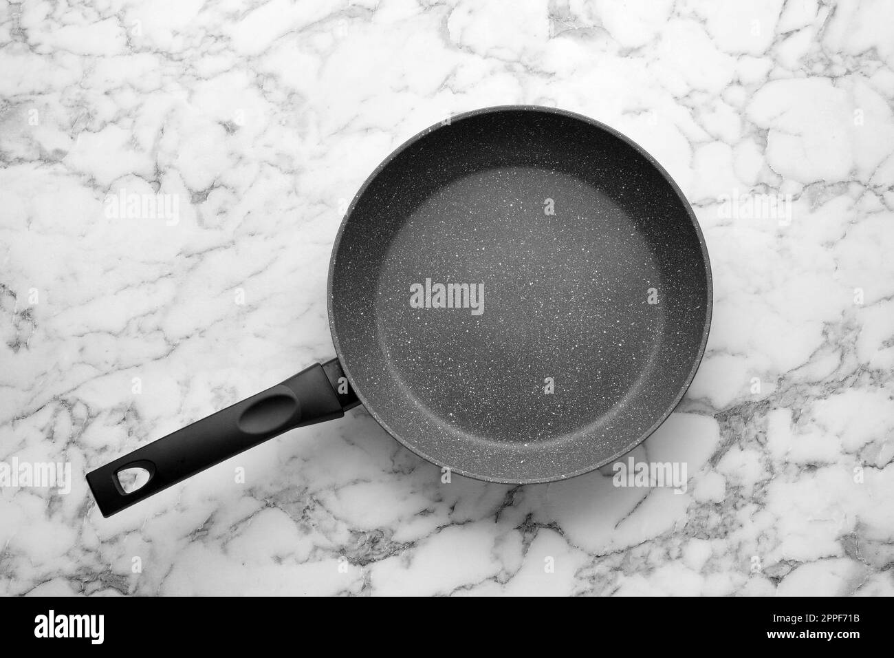 New non-stick frying pan on white marble table, top view Stock Photo
