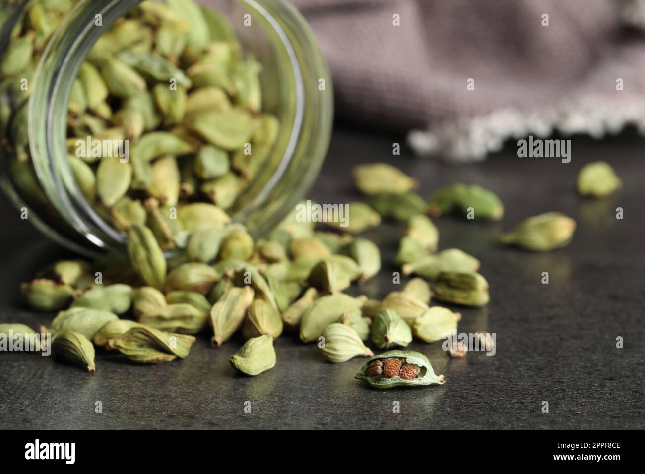 Jar with dry cardamom pods on dark grey table Stock Photo Alamy