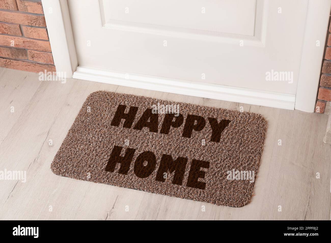 Door Mat With Words Happy Home On Wooden Floor In Hall Above View