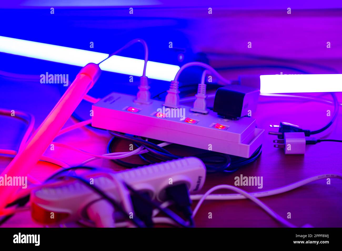 Many plugs connected to the power strip with individual switches Stock