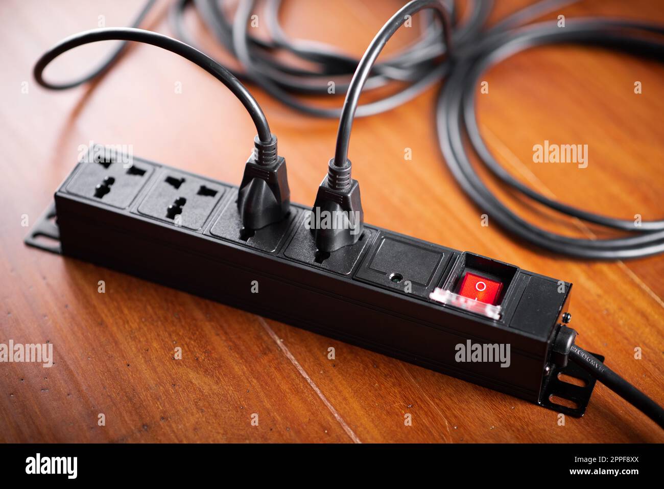 Many plugs connected to the black power strip Stock Photo Alamy
