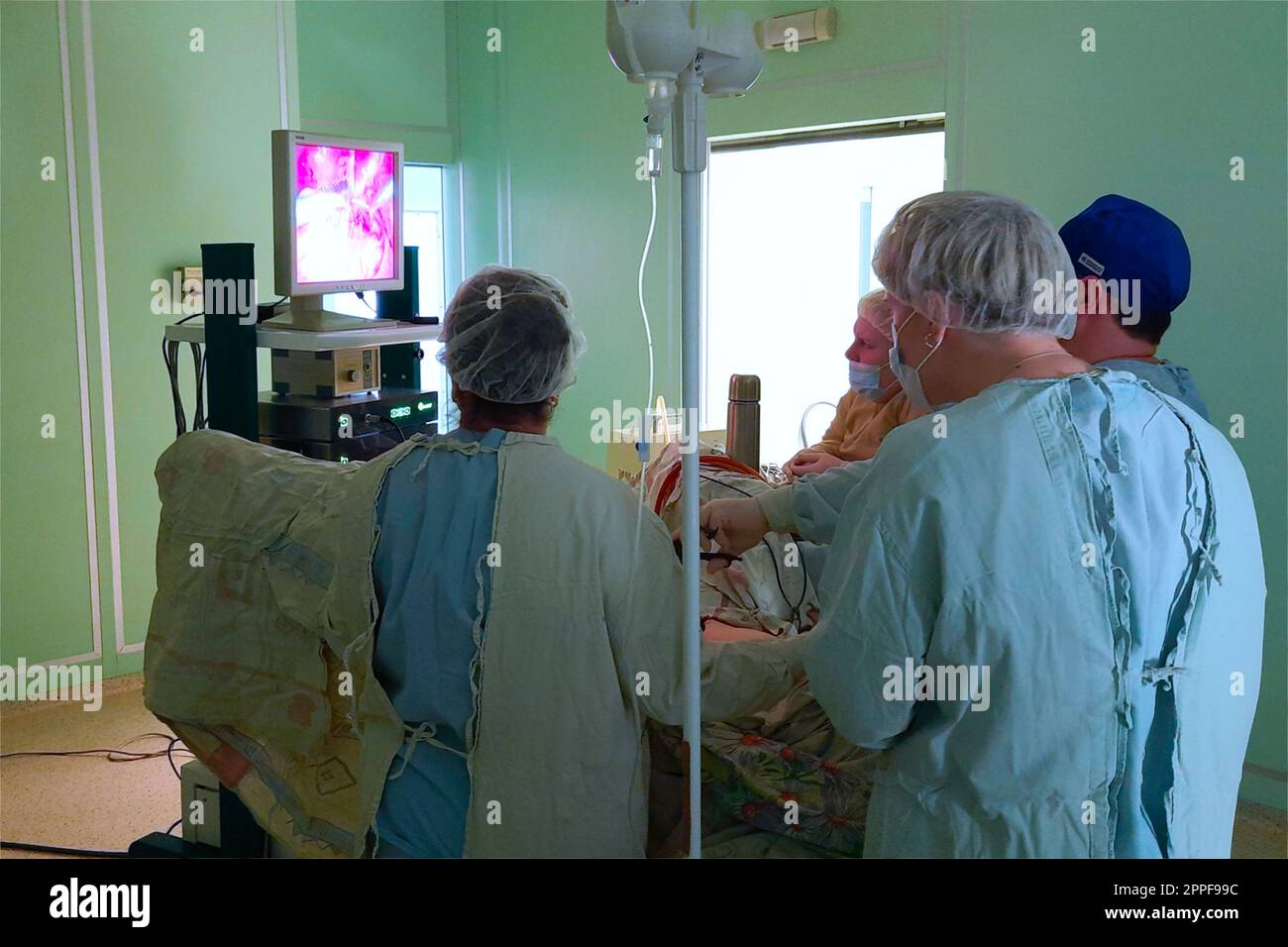 True Laparoscopic Surgery. A team of surgeons looks at the monitor during an operation Stock Photo