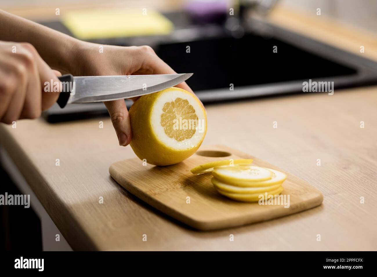 Hand cuts lemon knife hi-res stock photography and images - Alamy